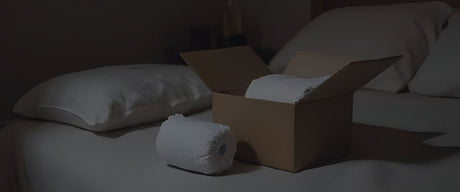 a box of adult diapers next to a nice bed
