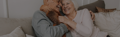 old woman hugging partner on couch