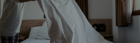 person cleaning sheets with urine on them